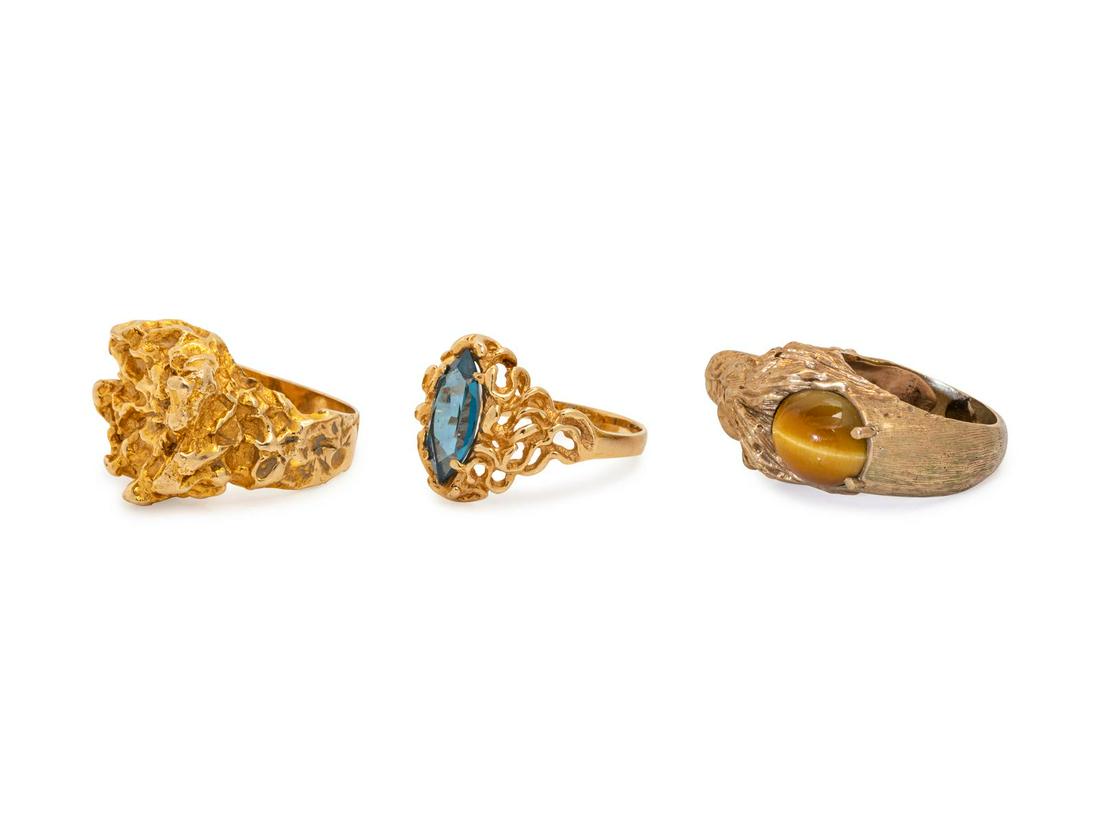 A Collection of Yellow Gold Rings,: A Collection of Yellow Gold Rings, consisting of a 10 karat lion motif ring containing one oval shape cabochon cut tiger's eye, a 14 karat ring containing one marquise cut synthetic blue spinel, toget