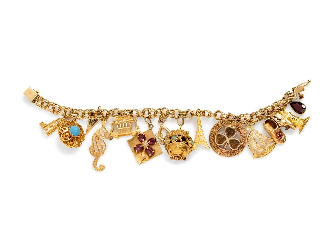 A Yellow Gold Charm Bracelet,: A Yellow Gold Charm Bracelet, consisting of a 14 karat gold link bracelet suspending 14 charms including a 14 karat lighthouse charm, an openwork charm, a Holy Cross pennant charm, a 14 karat seahorse