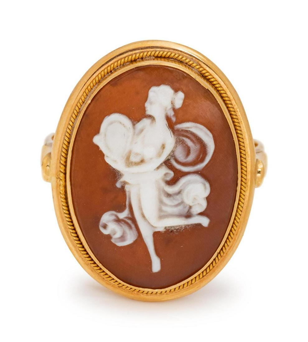 A Yellow Gold and Shell Cameo Ring, : A Yellow Gold and Shell Cameo Ring, containing one oval shape carved shell cameo depicting a woman, measuring approximately 17.40 x 12.95 mm. Stamp: (obscured). 2.90 dwts. Provenance: Property of an