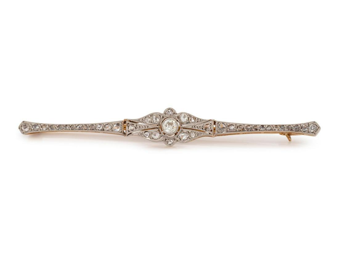 An Edwardian Platinum Topped 18 Karat Yellow Gold and: An Edwardian Platinum Topped 18 Karat Yellow Gold and Diamond Bar Brooch, containing one old European cut diamond weighing approximately 0.10 carat and numerous rose and mixed cut diamonds, with mille