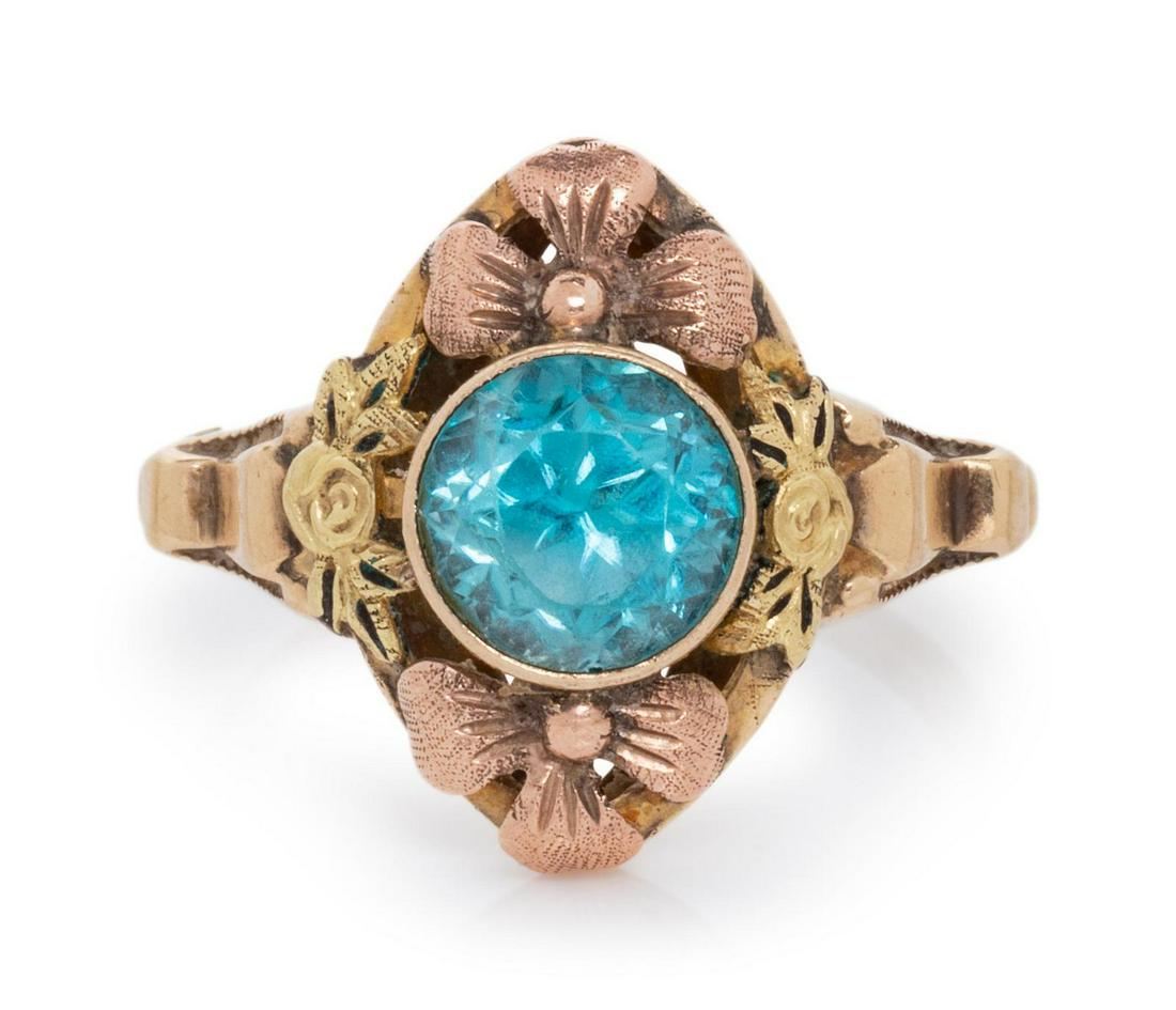 A 10 Karat Bicolor Gold and Blue Zircon Floral Motif: A 10 Karat Bicolor Gold and Blue Zircon Floral Motif Ring, containing one round mixed cut blue zircon measuring approximately 7.35 mm in diameter. Stamp: OB 10K. 2.20 dwts. Provenance: