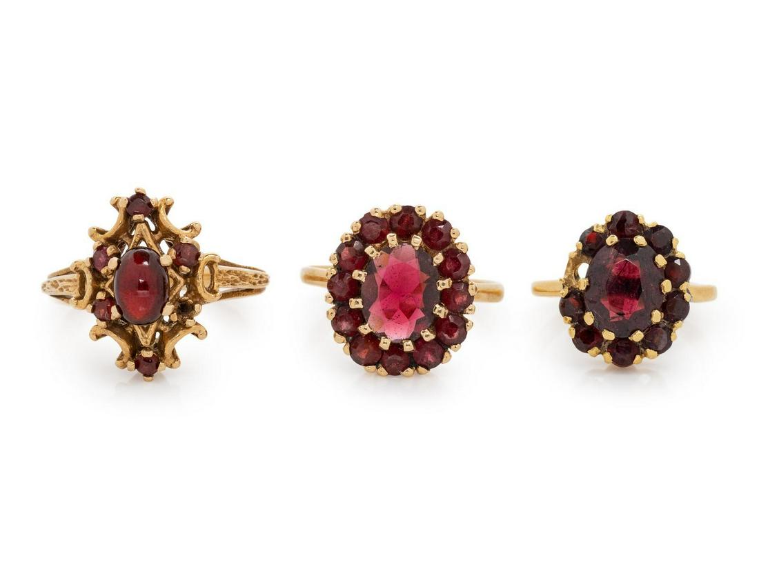 A Collection of Yellow Gold and Garnet Rings,: A Collection of Yellow Gold and Garnet Rings, consisting of a ring containing one oval cabochon cut garnet measuring approximately 7.00 x 5.00 mm and five round mixed cut garnets, a ring containing on