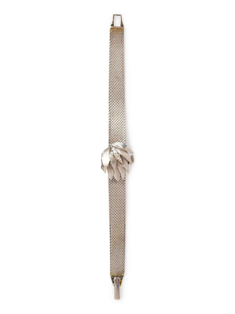 A 14 Karat White Gold and Diamond Surprise Watch,: A 14 Karat White Gold and Diamond Surprise Watch, Omega, the hinged cover containing six single cut diamonds, matte silvered dial signed OMEGA, applied baton numerals, black pencil hands, 17 jewel m
