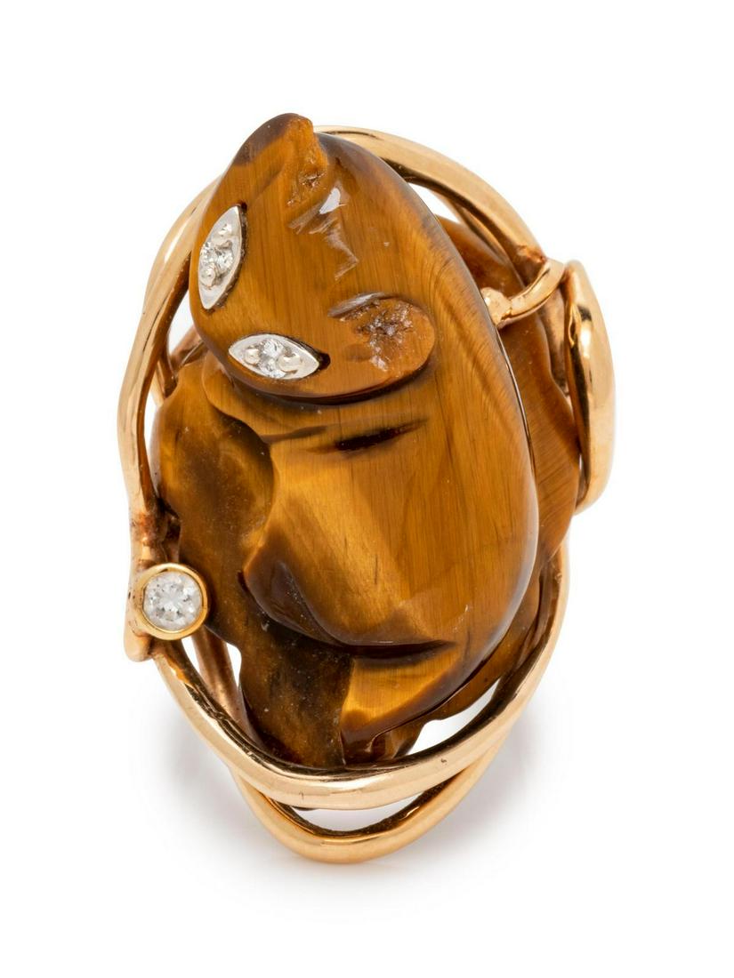 A Yellow Gold, Tiger's Eye and Diamond Ring,: A Yellow Gold, Tiger's Eye and Diamond Ring, containing a carved tiger's eye cat figure and three round brilliant cut diamonds. 9.95 dwts. Provenance: Property from the Collection of Olga Garoufalis, 