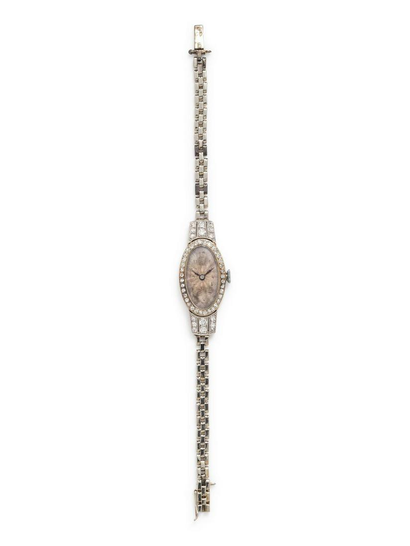 An Art Deco White Gold and Diamond Wristwatch, Rolex,: An Art Deco White Gold and Diamond Wristwatch, Rolex, the bezel and lugs containing numerous round brilliant and single cut diamonds, 15.00 x 25.00 mm case dimensions, guilloche engraved dial, black A