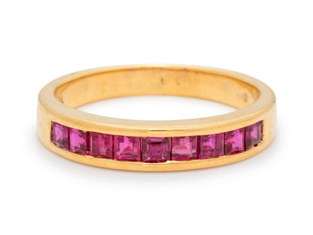 An 18 Karat Yellow Gold and Ruby Ring,: An 18 Karat Yellow Gold and Ruby Ring, containing nine square step cut rubies measuring approximately 2.00 x 2.00 mm. Stamp: 182150 (Kurt Wayne maker's mark). 2.90 dwts. Provenance: