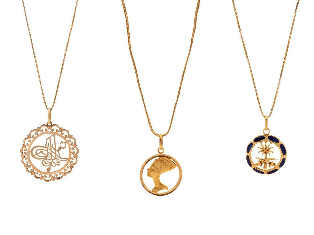 A Collection of Yellow Gold Pendant/Necklaces,: A Collection of Yellow Gold Pendant/Necklaces, consisting of an 18 karat gold and blue enamel Saudi Arabia emblem pendant suspended from an 18 karat gold Italian box chain necklace, a 14 karat gold Tu