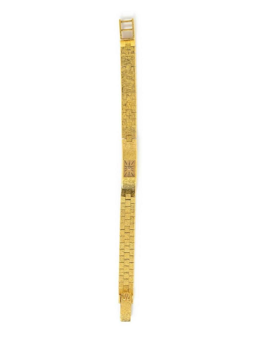 A Yellow Gold Wristwatch, Omega,: A Yellow Gold Wristwatch, Omega, 20.00 x 8.00 mm case dimensions, brushed gold dial signed OMEGA, black baton numerals, gold pencil hands, integrated textured link bracelet, fold over clasp. Clasp sta