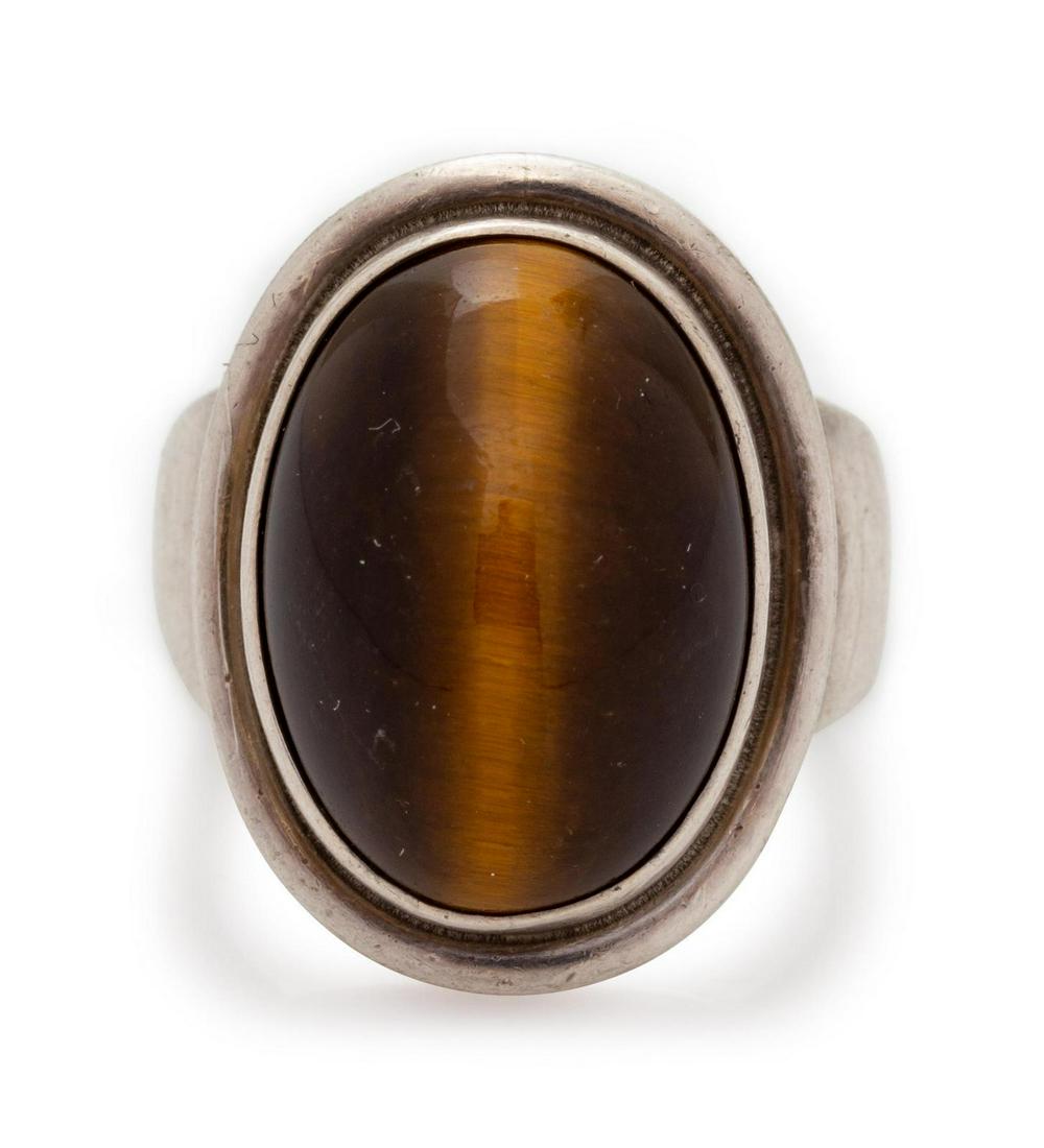 A Sterling Silver and Tiger's Eye Ring, Harald Nielsen: A Sterling Silver and Tiger's Eye Ring, Harald Nielsen for Georg Jensen, containing one oval shape cabochon cut tiger's eye measuring approximately 17.60 x 12.95 mm. Stamp: (maker's mark) 925 S DENMAR
