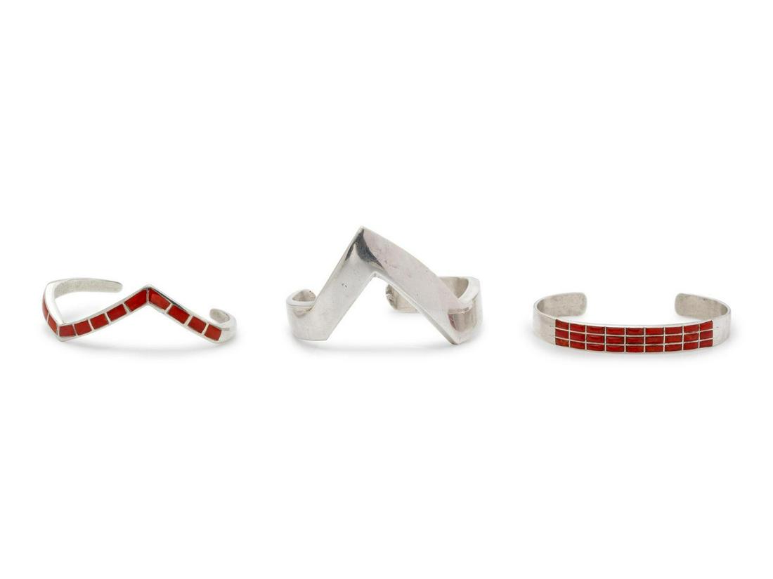 A Collection of Silver Cuff Bracelets, : A Collection of Silver Cuff Bracelets, consisting of a silver zig zag cuff bracelet, a zig zag cuff bracelet with red enamel, together with a silver cuff containing rectangular carnelian. 61.20 dwts