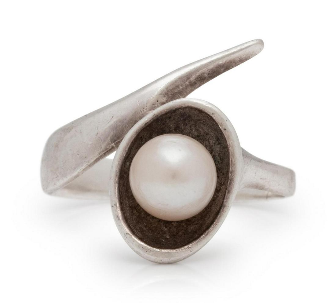A Silver and Cultured Pearl Ring, Ed Wiener,: A Silver and Cultured Pearl Ring, Ed Wiener, unsigned, consisting of a sculptural ring containing one pearl measuring approximately 6.50 mm in diameter. 3.40 dwts. Provenance: Property of a University