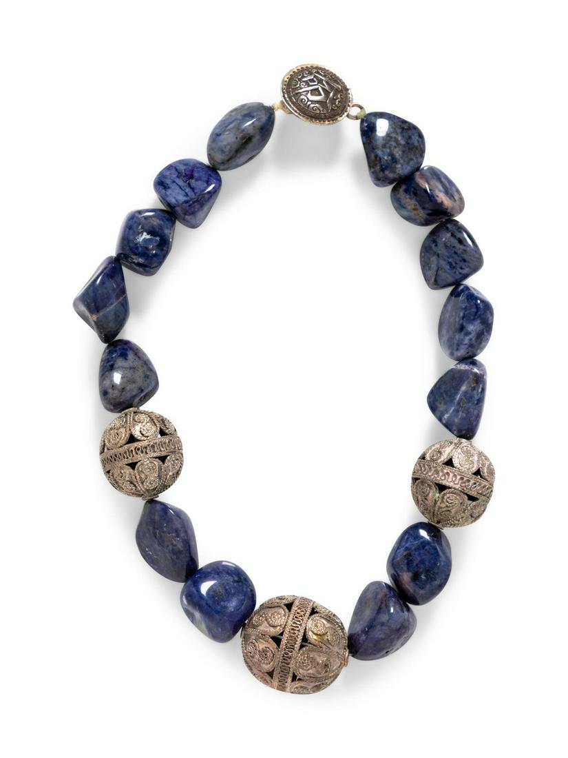 A Sodalite and Silver Bead Necklace: A Sodalite and Silver Bead Necklace containing 14 tumbled sodalite beads interspersed with three round filigree beads and decorative clasp. 135.00 dwts. Provenance: