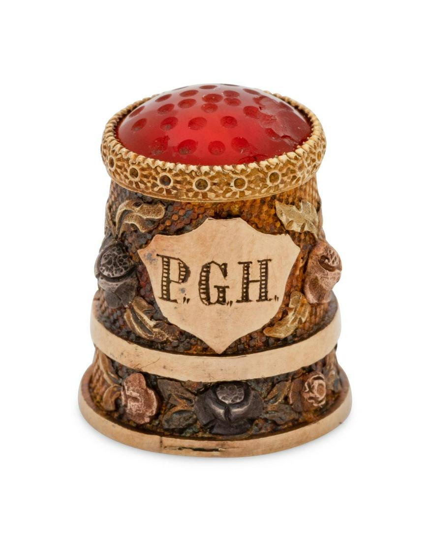 A Continental Gold, Silver and Hardstone Inset Child: A Continental Gold, Silver and Hardstone Inset Child's Thimble Late 18th/Early 19th Century having a hardstone-inset cap, the body with applied floral sprays surrounding a shield crest engraved P.G.H.