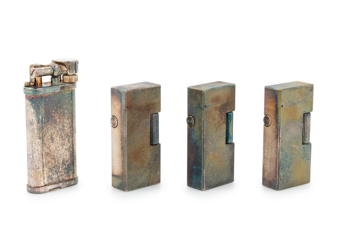 Four Dunhill Silver-Plate Lighters: Four Dunhill Silver-Plate Lighters First Half 20th Century and Later each case with engine-turned decoration. Height of tallest 2 1/2 inches. Property from a Midwest Collector