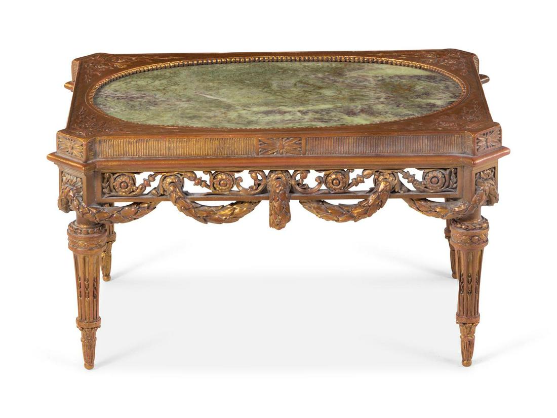 A Louis XVI Style Parcel Gilt Low Table: A Louis XVI Style Parcel Gilt Low Table 20th Century Height 13 x width 21 3/4 x depth 15 inches. The oval marble inset in the rectangular top, above a scrolling foliate apron, raised on carved legs.