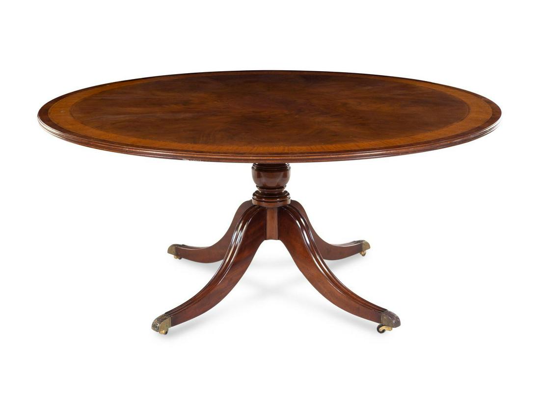 A George III Style Mahogany Tilt-Top Breakfast Table: A George III Style Mahogany Tilt-Top Breakfast Table 20TH CENTURY Height 29 5/8 inches. Diameter of top 65 3/4 inches. The oval top tilting above a baluster standard on four downswept legs on casters.
