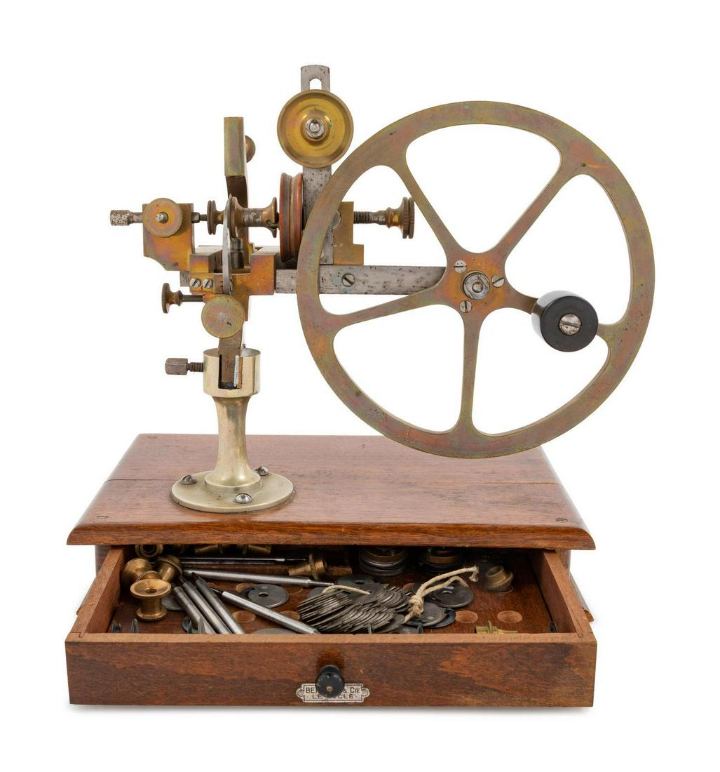 A Swiss Brass and Steel Watch Maker's Rounding Up Tool: A Swiss Brass and Steel Watch Maker's Rounding Up Tool Bergeon & Cie, Late 19th/Early 20th Century mounted to a wood base with various accessories and cutters in base drawer.Â Height 10 1/4 inches 