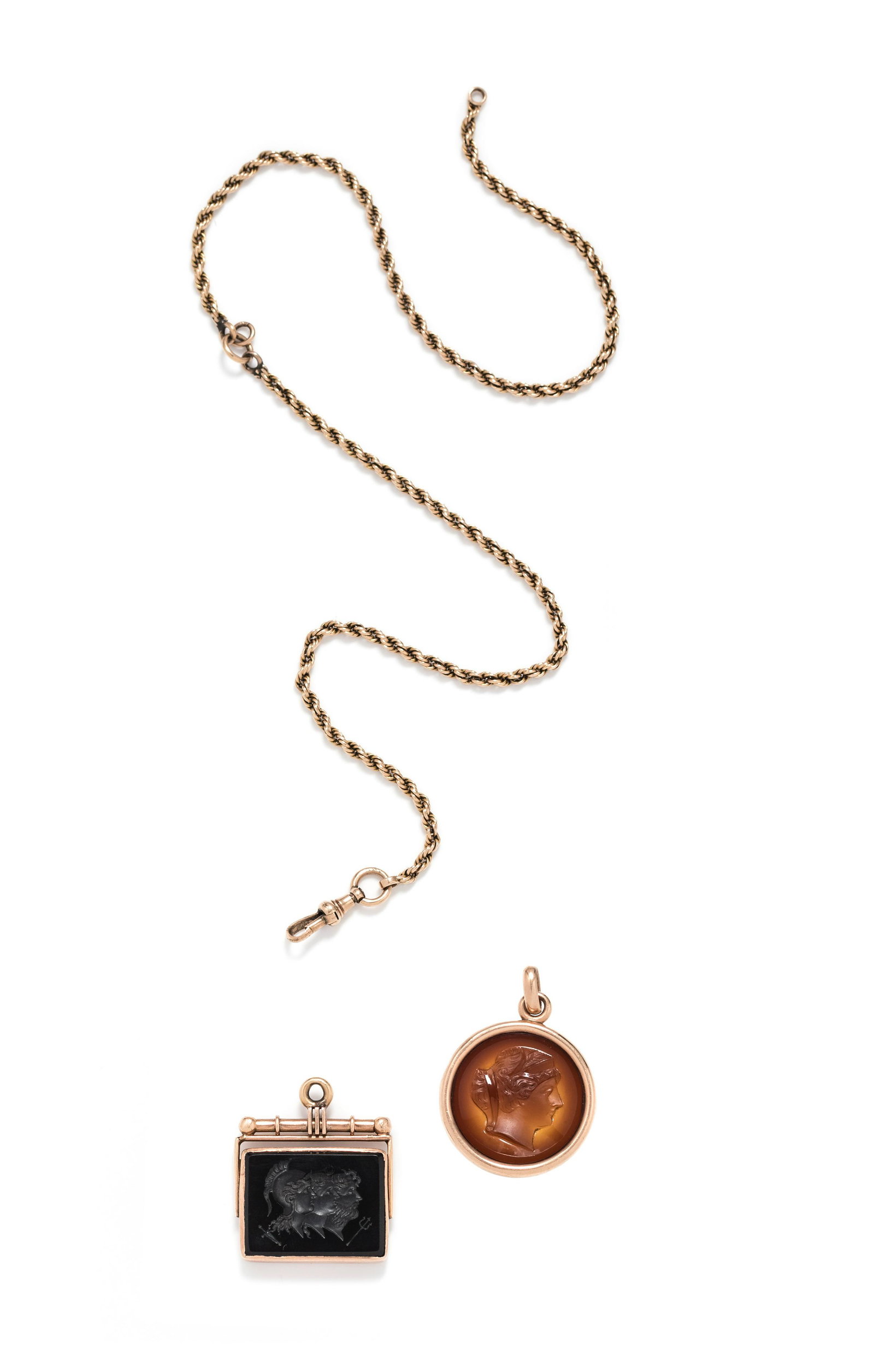 COLLECTION OF INTAGLIO PENDANTS: COLLECTION OF INTAGLIO PENDANTS Consisting of a round intaglio pendant depicting a male profile and a rectangular intaglio depicting three mythical male profiles, together with a rose gold fob chain. 