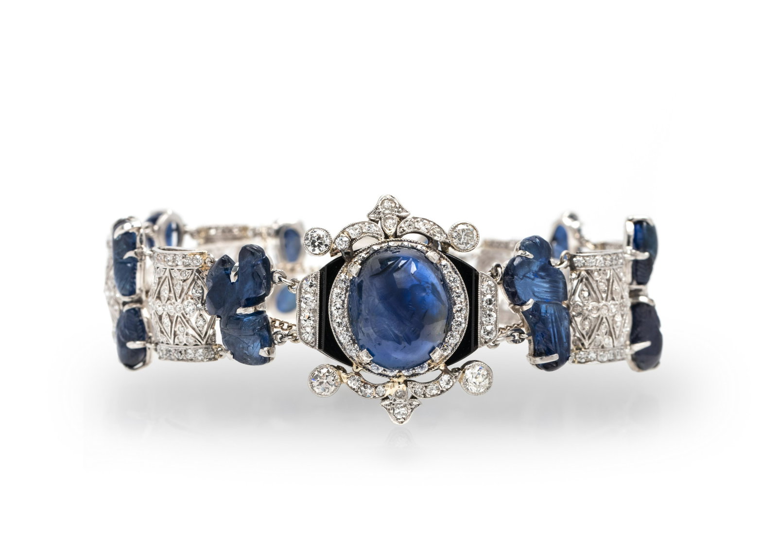 SAPPHIRE, DIAMOND AND ONYX BRACELET: SAPPHIRE, DIAMOND AND ONYX BRACELET Containing one oval shape cabochon cut intaglio sapphire measuring approximately 14.45 x 12.05 x 6.80 mm surmounted on an onyx plaque, 14 carved sapphires, four old