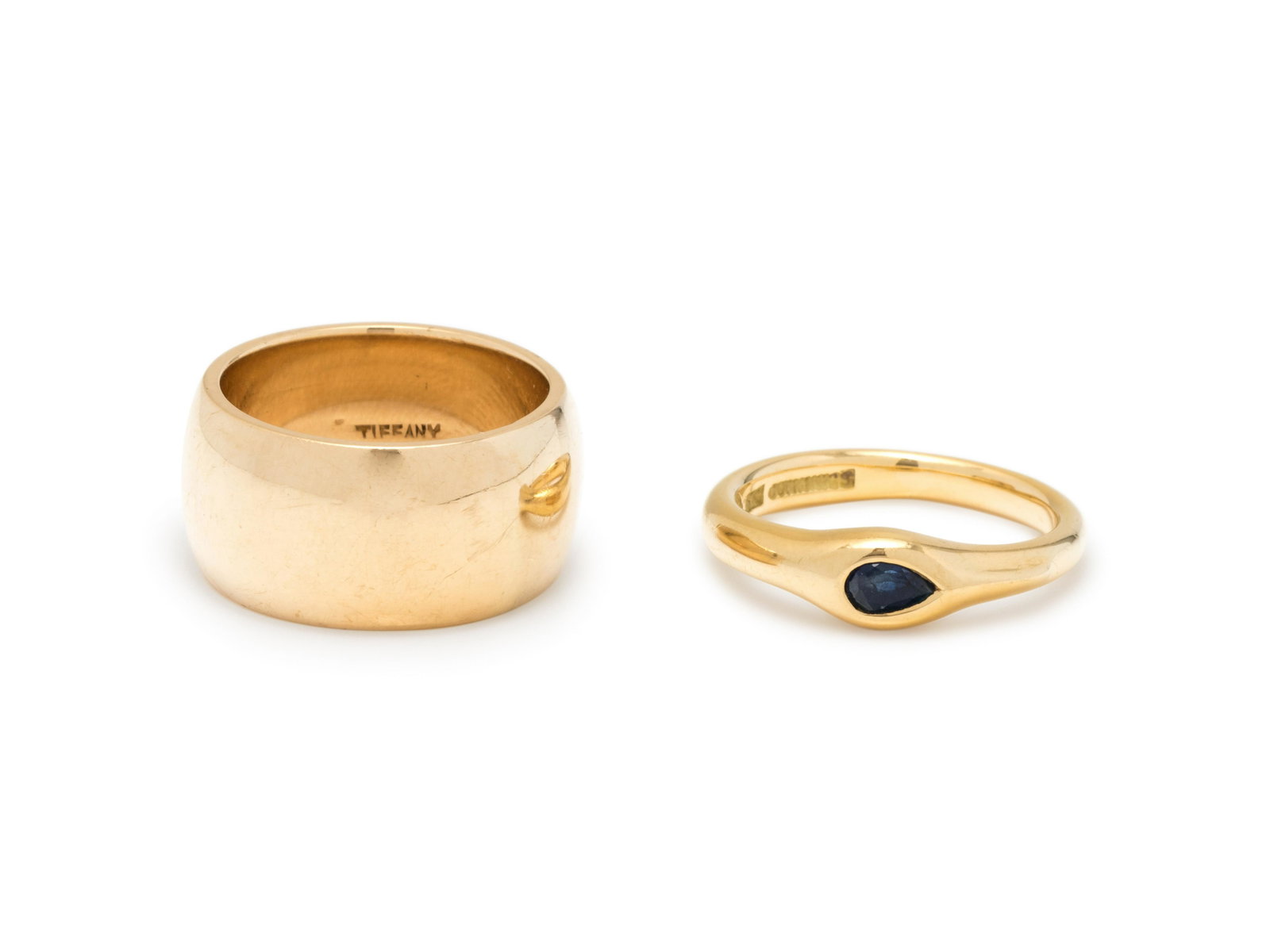 TIFFANY & CO., COLLECTION OF YELLOW GOLD RINGS: TIFFANY & CO., COLLECTION OF YELLOW GOLD RINGS Consisting of a ring containing one pear shape sapphire measuring approximately 4.50 x 2.50 mm, together with a band measuring approximately 9.50 mm wide