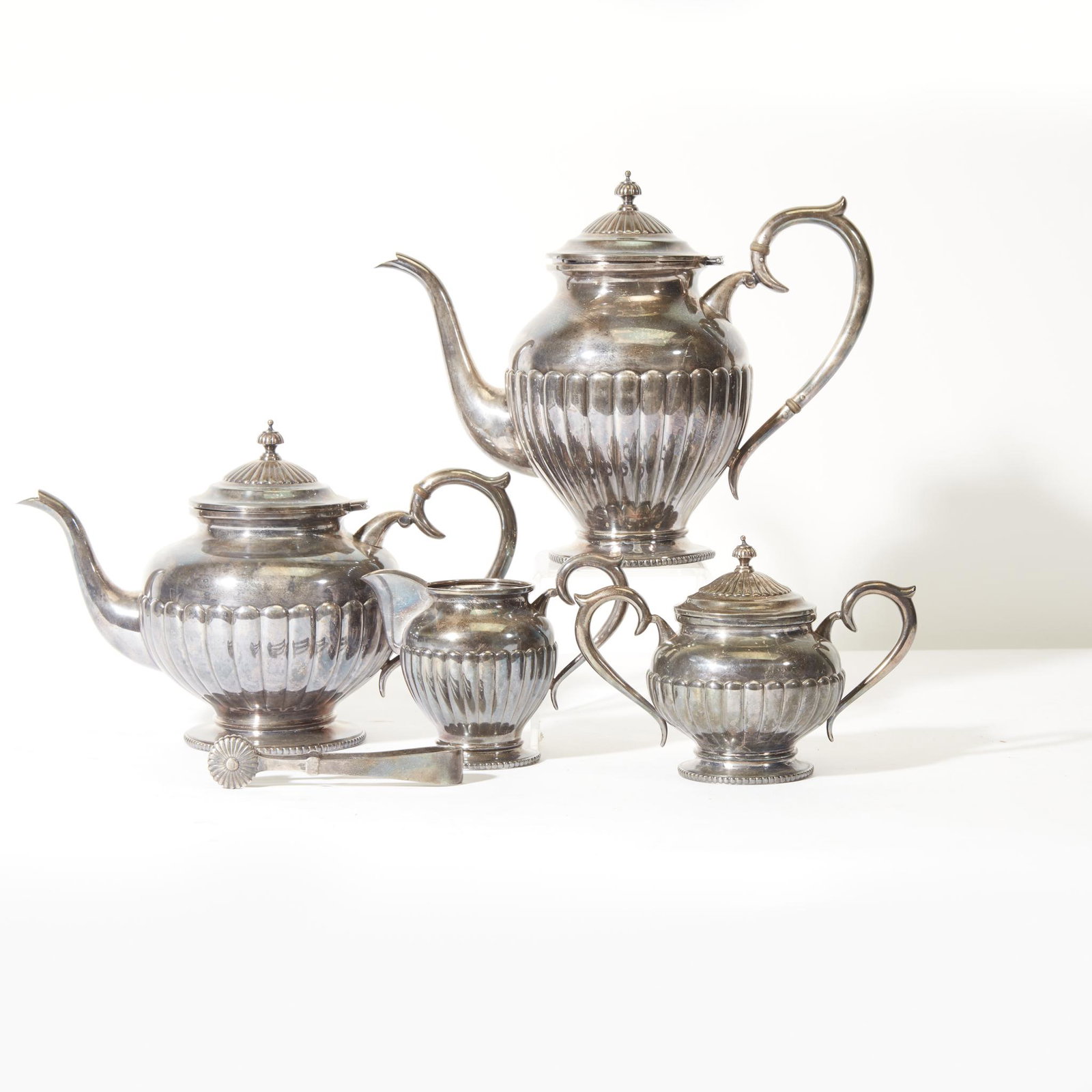 A five-piece sterling silver tea and coffee service,: A five-piece sterling silver tea and coffee service, 20th century. Comprising a coffeepot, a teapot, a cover sugar dish, a creamer, and sugar tongs, all marked "Sterling 950"; together with traveling 