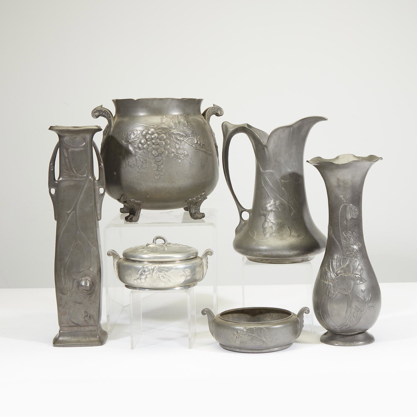 Kayserzinn (German, active 1862-1925), Collection of: Kayserzinn (German, active 1862-1925) Collection of six pewter wares, Germany, early 20th century. Including a pair of twin handled covered bowls (one lid), a grape decorated pitcher, two tall vases a