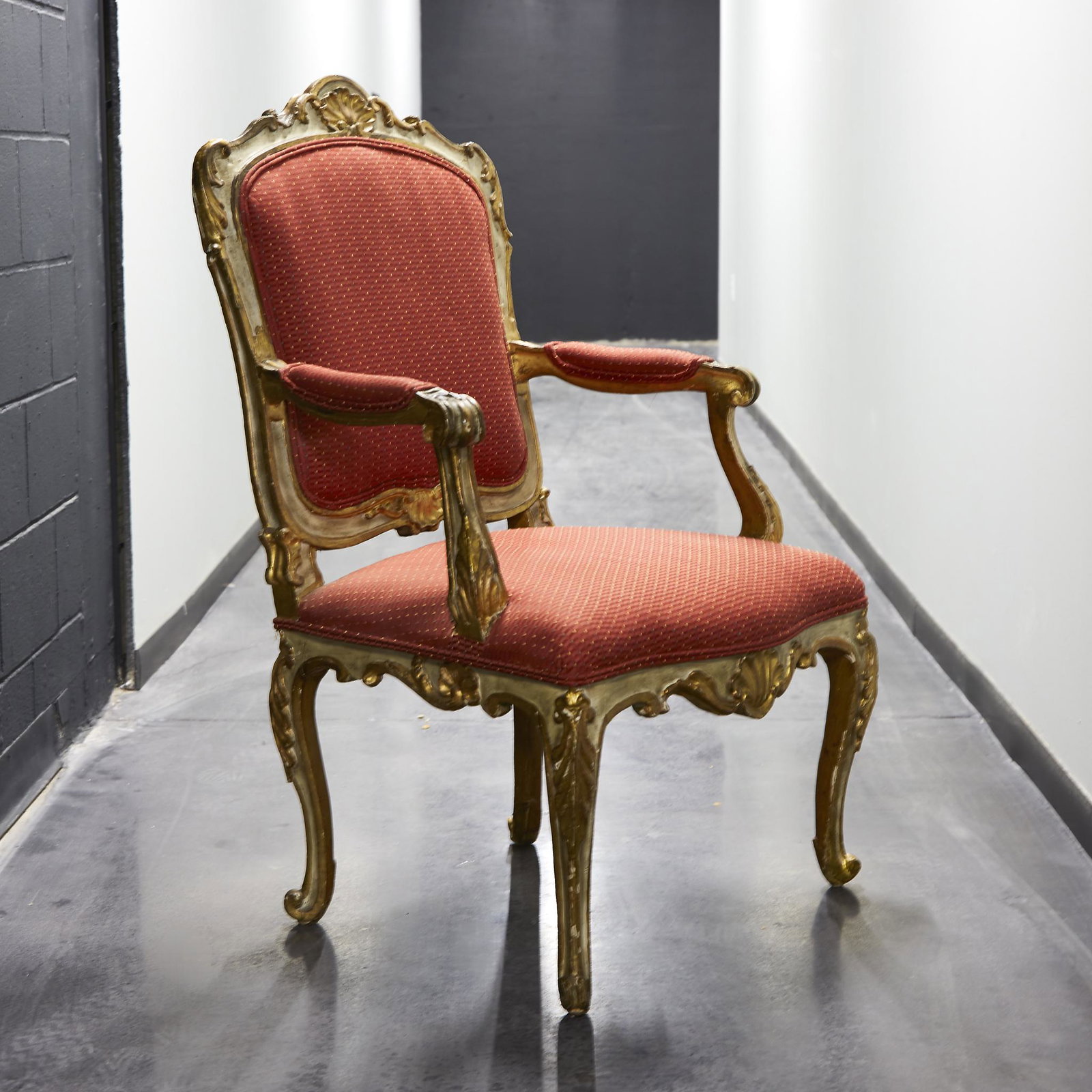 An Italian Rococo white painted and parcel-gilt: An Italian Rococo white painted and parcel-gilt armchair, mid 18th century. H: 48 in., W: 28 i9n., D: 25 in.