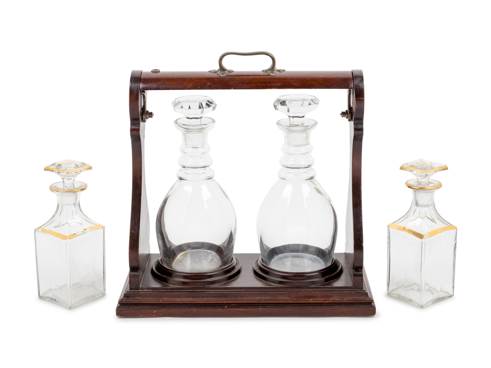 An Edwardian Mahogany Two-Bottle Tantalus: An Edwardian Mahogany Two-Bottle Tantalus together with a pair of gilt decorated glass bottles. Height 14 1/2 inches Property from Christa's Ltd., Chicago, Illinois