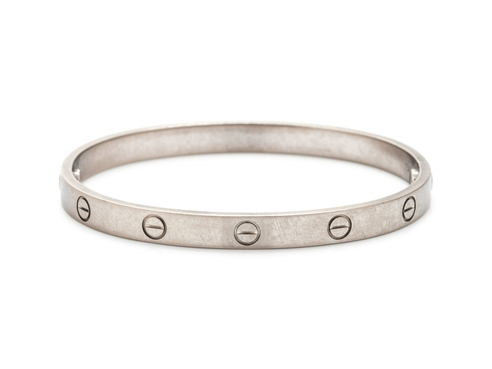 CARTIER, WHITE GOLD 'LOVE' BRACELET: CARTIER, WHITE GOLD 'LOVE' BRACELET In a two piece construction joined with two threaded screws. Stamp: Cartier 750 18 TE 6347 (maker's mark). 22.00 dwt. Accompanied by a Cartier pouch and certificate