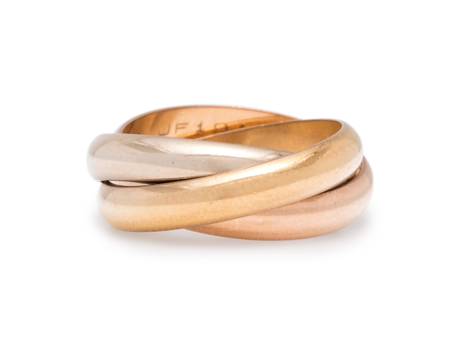 CARTIER, TRICOLOR GOLD: CARTIER, TRICOLOR GOLD 'TRINITY' RING Consisting of interlocking rose, white and yellow gold rings. Stamp: (Hallmark) 750 Cartier 57 JF191. 7.95 dwt. Accompanied by a Cartier certificate of authentici