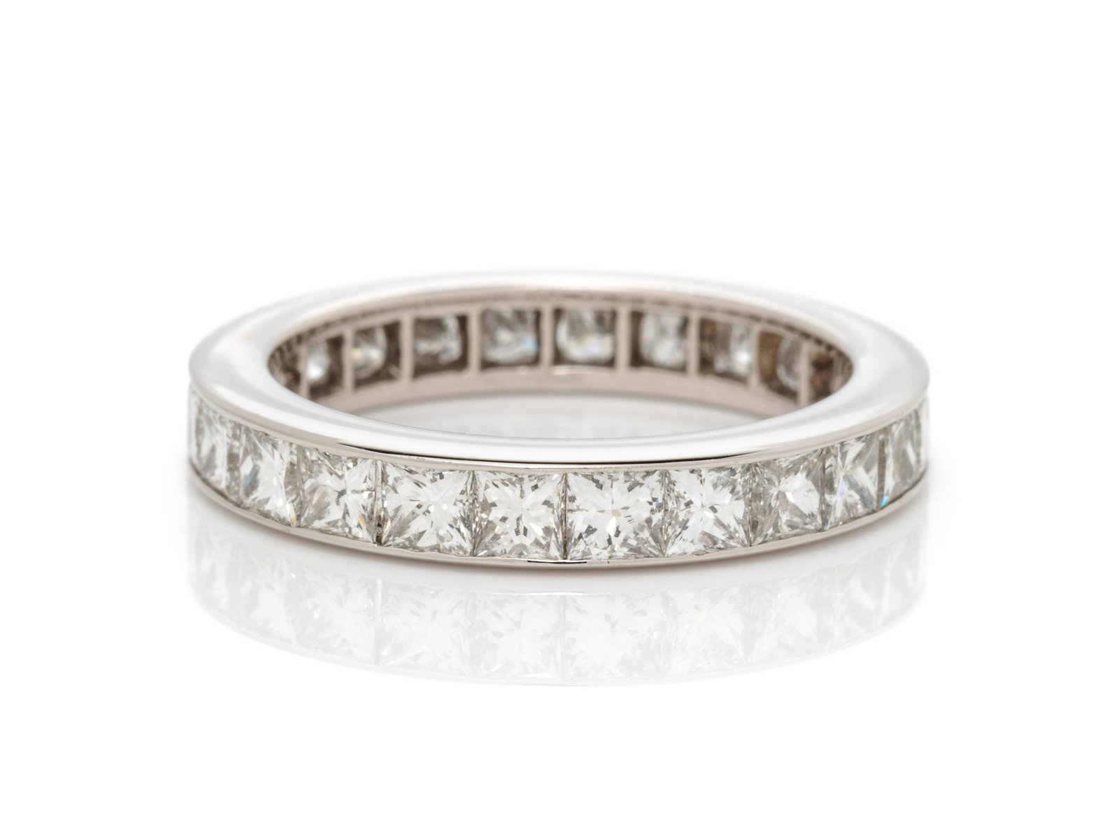 HARRY WINSTON, DIAMOND ETERNITY BAND: HARRY WINSTON, DIAMOND ETERNITY BAND Containing 24 princess cut diamonds weighing approximately 2.40 carats total. Mounted in platinum. Ring size 4 3/4. Stamp: (maker's mark) PT 950 281906. 2.70 dwt.