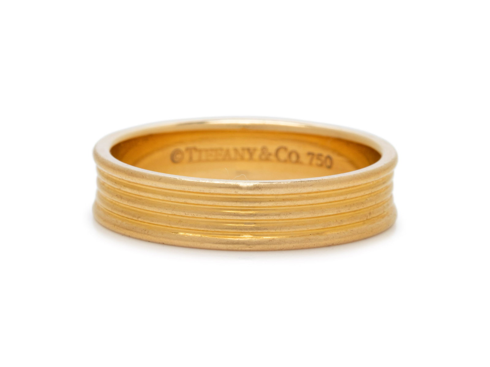 TIFFANY & CO., YELLOW GOLD RING: TIFFANY & CO., YELLOW GOLD RING In a horizontal ribbed design measuring approximately 5.00 mm wide. Stamp: TIFFANY & CO. 750. 3.60 dwt.