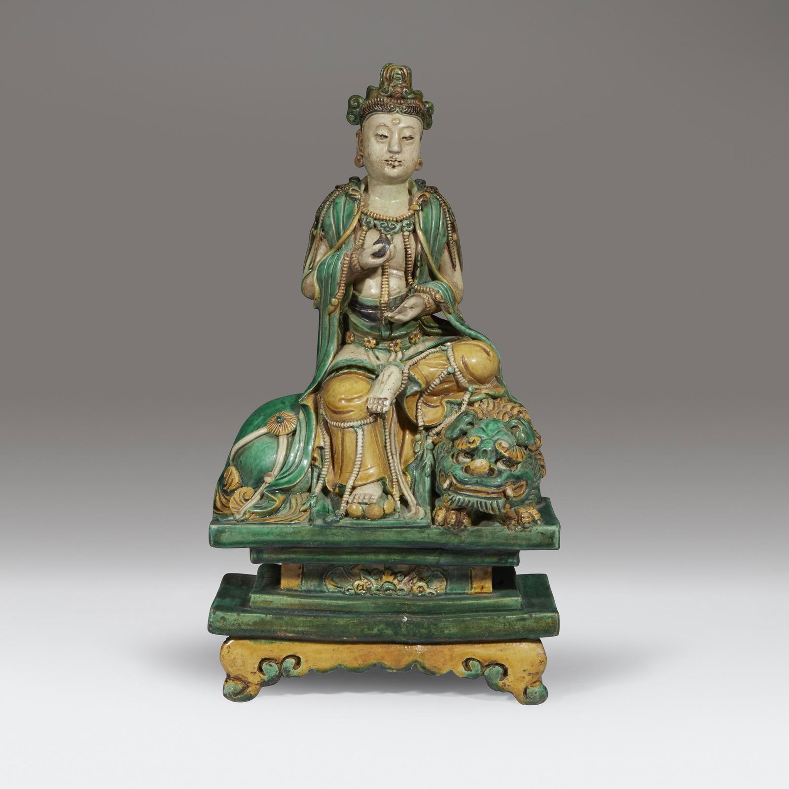 A Chinese sancai-glazed figure of a seated Bodhisattva, (1 of 3)