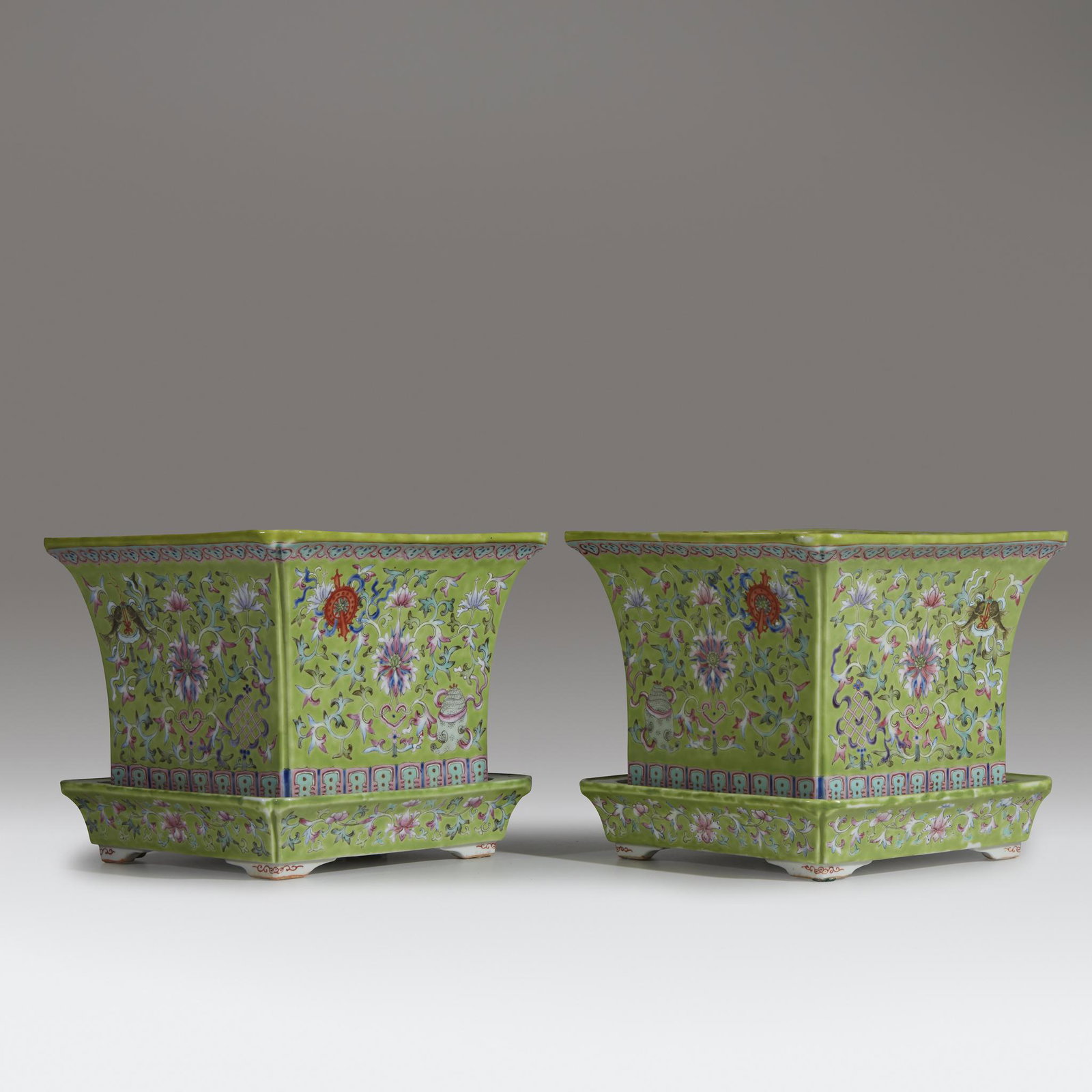 A pair of Chinese lime-green ground square jardinieres: A pair of Chinese lime-green ground square jardinieres and standsQing dynasty,19th centuryDecorated with lotus scrolls and the eight Buddhist treasures, stylized lappet borders at the base (2). H: 7 1