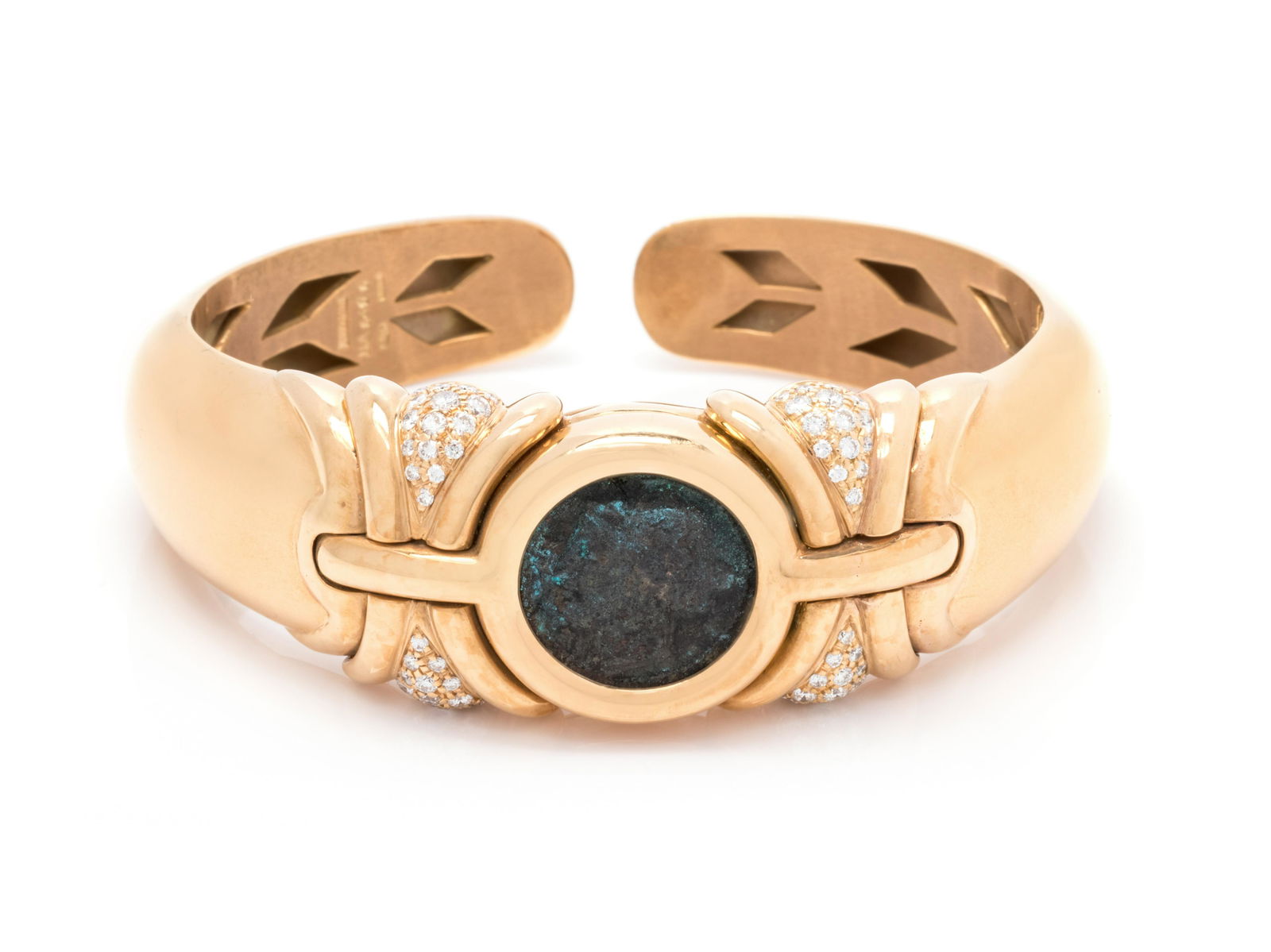 BVLGARI, YELLOW GOLD, ANCIENT COIN AND DIAMOND CUFF: BVLGARI, YELLOW GOLD, ANCIENT COIN AND DIAMOND CUFF BRACELET Consisting of a semi-flexible cuff containing one ancient Roman tetradrachma coin and 64 round brilliant cut diamonds weighing approximatel