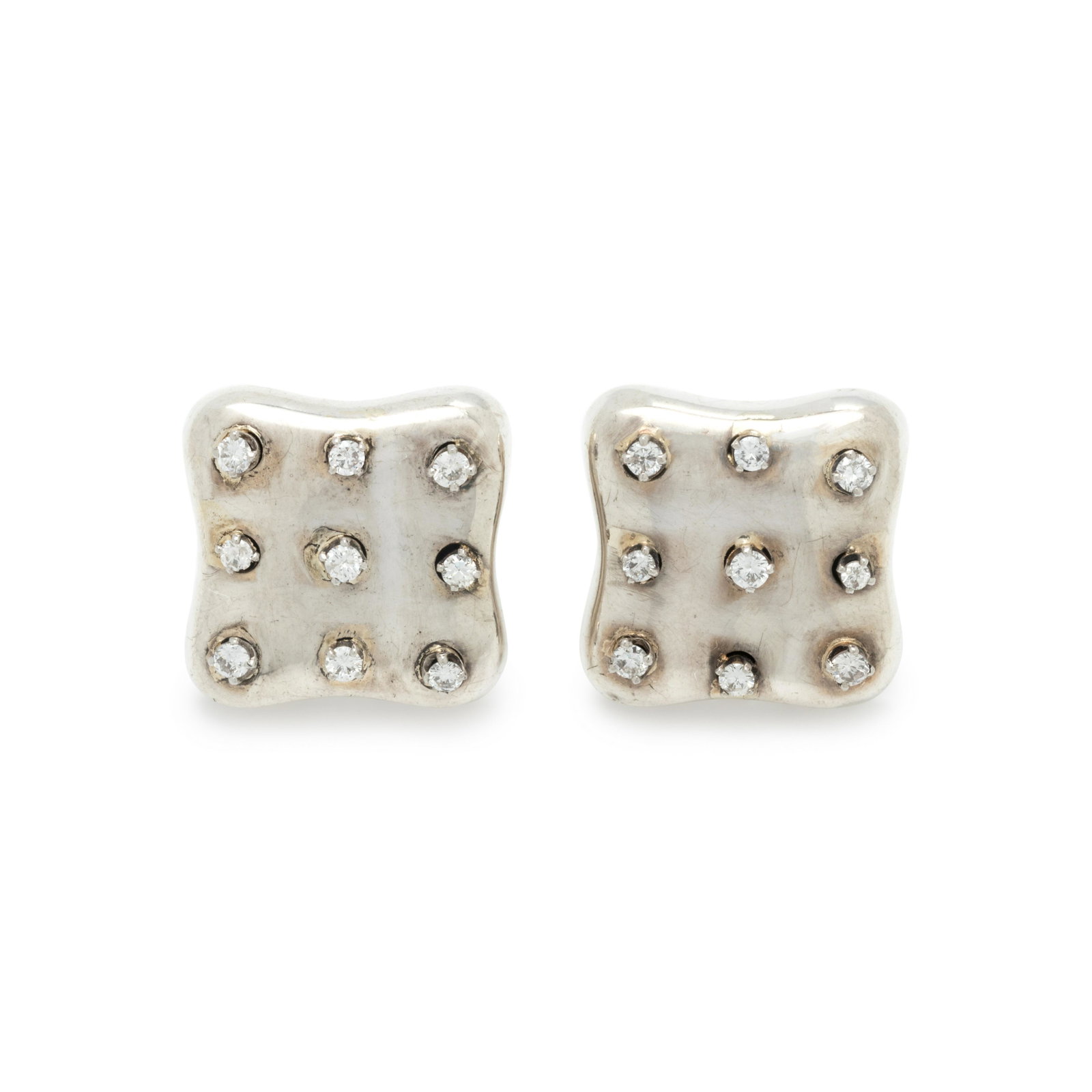 ANGELA CUMMINGS, STERLING SILVER AND DIAMOND EARCLIPS: ANGELA CUMMINGS, STERLING SILVER AND DIAMOND EARCLIPS In a hollow form, containing 18 round brilliant cut diamonds weighing approximately 0.90 carat total, posts with clip backs. Stamp: 1984 CUMMINGS 