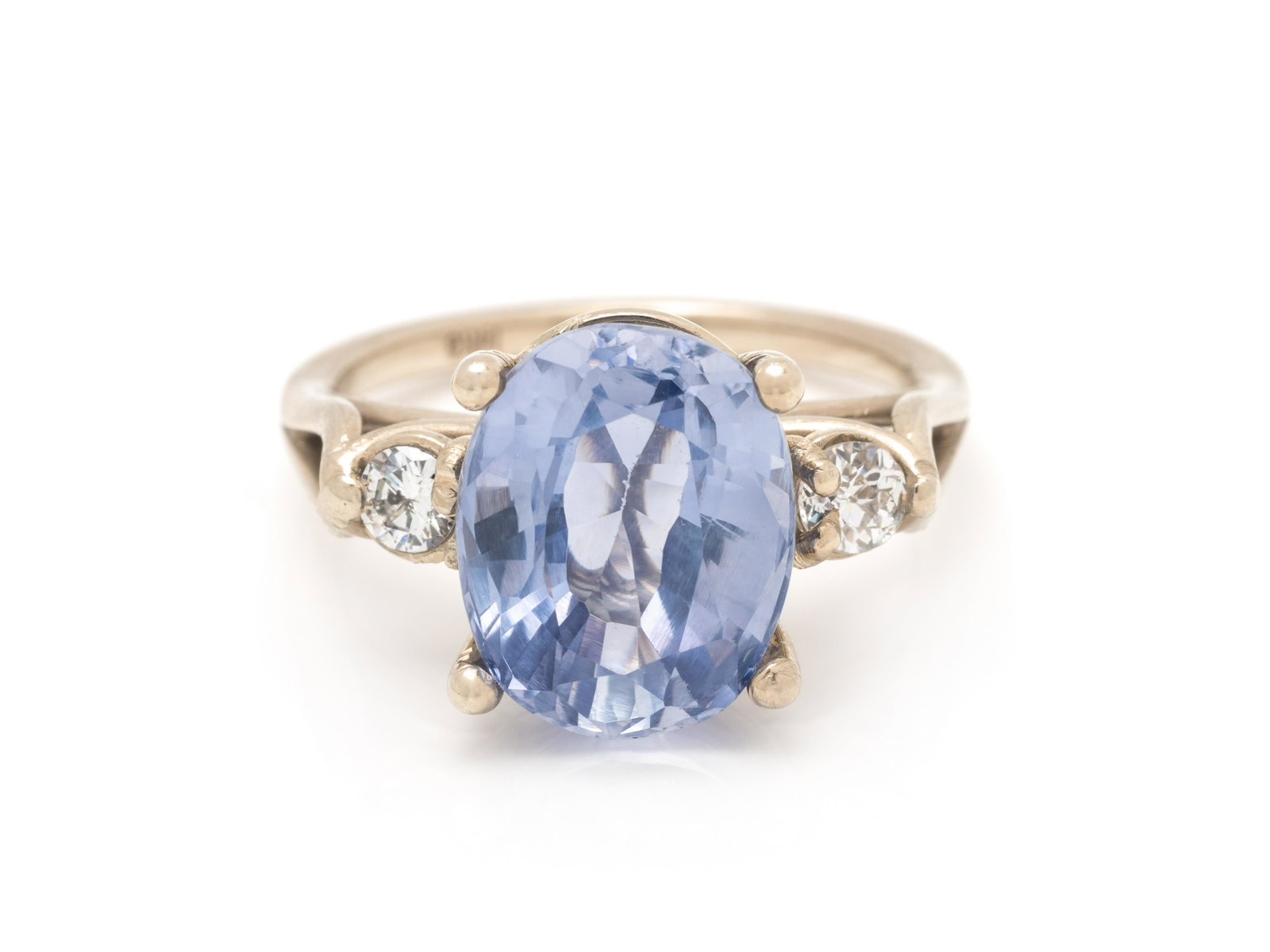 TANZANITE AND DIAMOND RING: TANZANITE AND DIAMOND RING Containing one oval mixed cut tanzanite measuring approximately 12.30 x 9.85 x 6.55 mm and two round brilliant cut diamonds weighing approximately 0.25 carat total. Mounted 