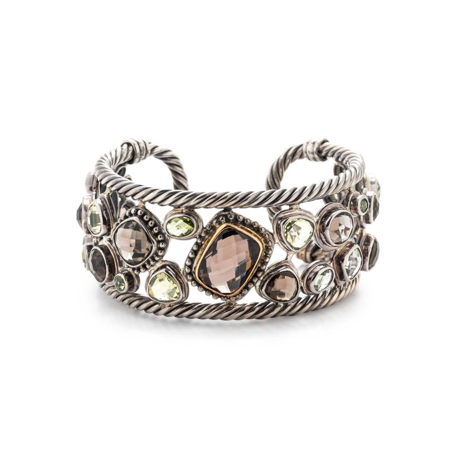 STERLING SILVER, YELLOW GOLD AND GEMSTONE CUFF BRACELET: STERLING SILVER, YELLOW GOLD AND GEMSTONE CUFF BRACELET Containing numerous checkerboard cut various shaped colored gemstones with a twisted cable surround. Stamp: BJC 925 18K. 46.35 dwt. Property fro