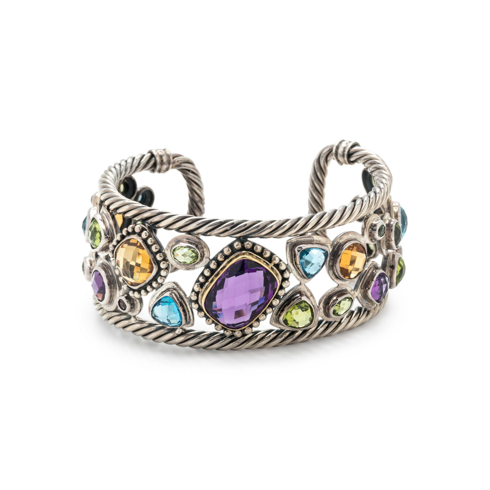 STERLING SILVER, YELLOW GOLD AND GEMSTONE CUFF BRACELET: STERLING SILVER, YELLOW GOLD AND GEMSTONE CUFF BRACELET Containing numerous checkerboard cut various shaped colored gemstones with a twisted cable surround. Stamp: BJC 18K 925. 41.20 dwt. Property fro