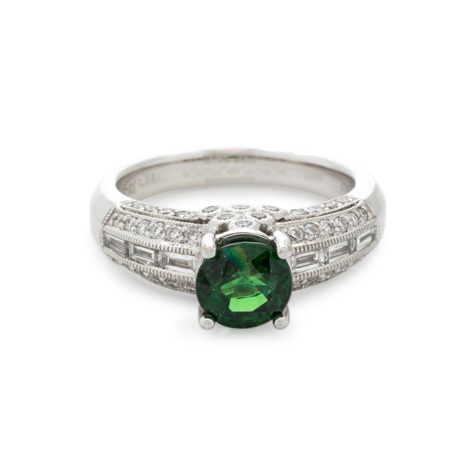 TSAVORITE GARNET AND DIAMOND RING: TSAVORITE GARNET AND DIAMOND RING Containing one off-round mixed cut tsavorite garnet measuring approximately 6.40-6.90 mm in diameter, six baguette cut diamonds weighing approximately 0.25 carat tota