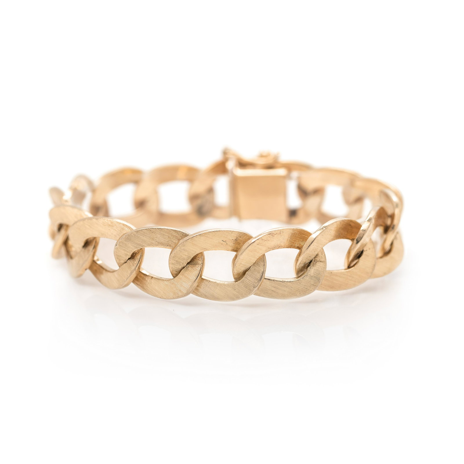 YELLOW GOLD BRACELET: YELLOW GOLD BRACELET Consisting of a textured curb link chain measuring approximately 13.85 mm wide. Stamp: 14K (obscured maker's mark). 30.20 dwt.