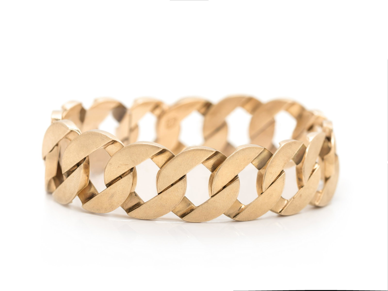 YELLOW GOLD BRACELET: YELLOW GOLD BRACELET Consisting of a flattened round curb link chain measuring approximately 18.60 mm wide. Stamp: SUCCO 14K. 37.80 dwt.