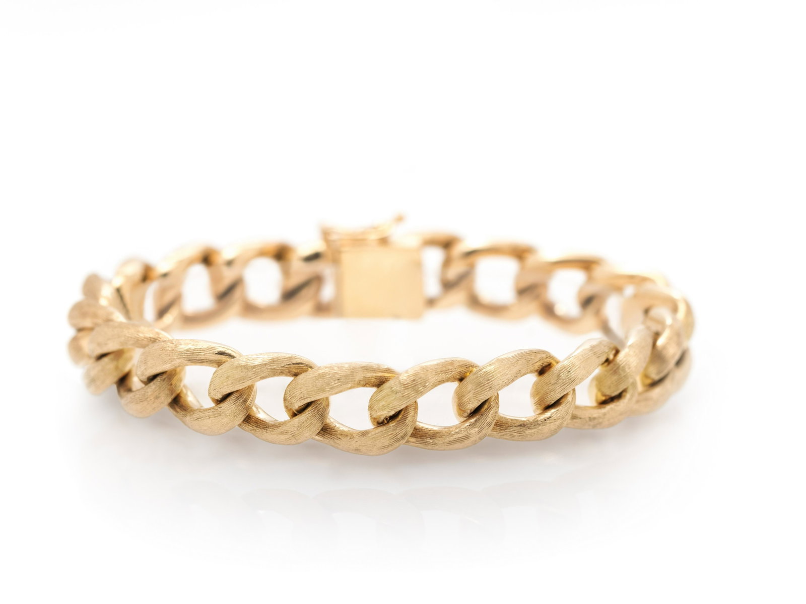 YELLOW GOLD BRACELET: YELLOW GOLD BRACELET Consisting of a textured curb link chain measuring approximately 10.40 mm wide. Stamp: (maker's mark for Zelman & Friedman) 14K. 28.95 dwt.