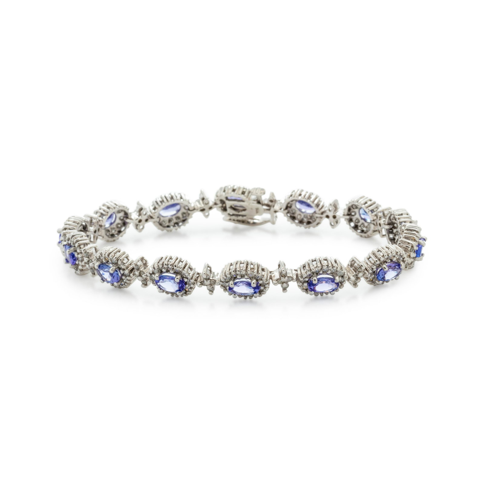 TANZANITE AND DIAMOND BRACELET: TANZANITE AND DIAMOND BRACELET Containing 14 oval mixed cut tanzanites measuring approximately 6.00 x 4.00 x 2.35 mm and numerous round brilliant cut diamonds weighing approximately 1.55 carats total.