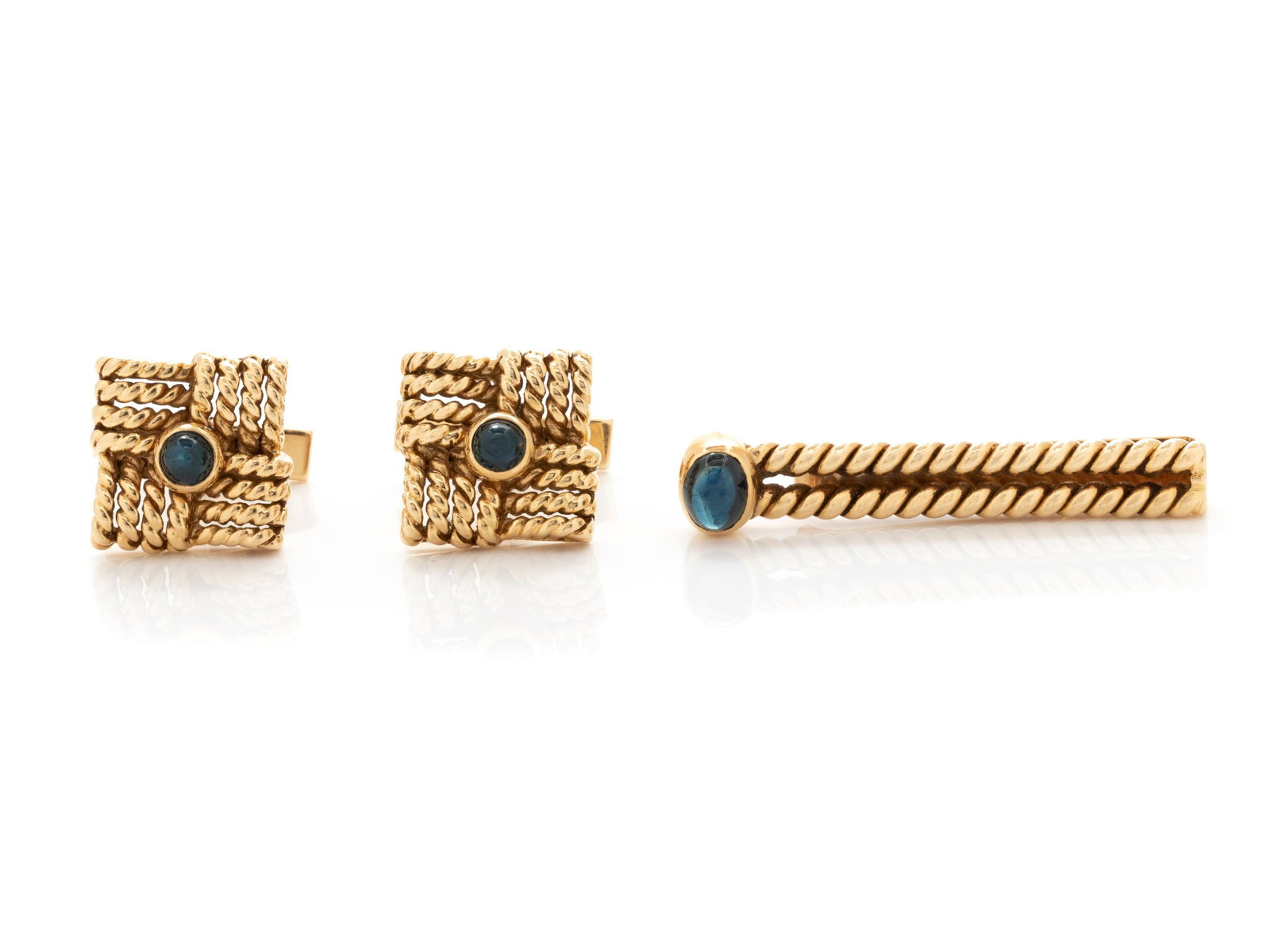 YELLOW GOLD AND SAPPHIRE CUFFLINKS AND TIE BAR SET: YELLOW GOLD AND SAPPHIRE CUFFLINKS AND TIE BAR SET Consisting of a pair of twisted gold wire cufflinks containing two round cabochon sapphires measuring approximately 4.30 mm in diameter, together wit