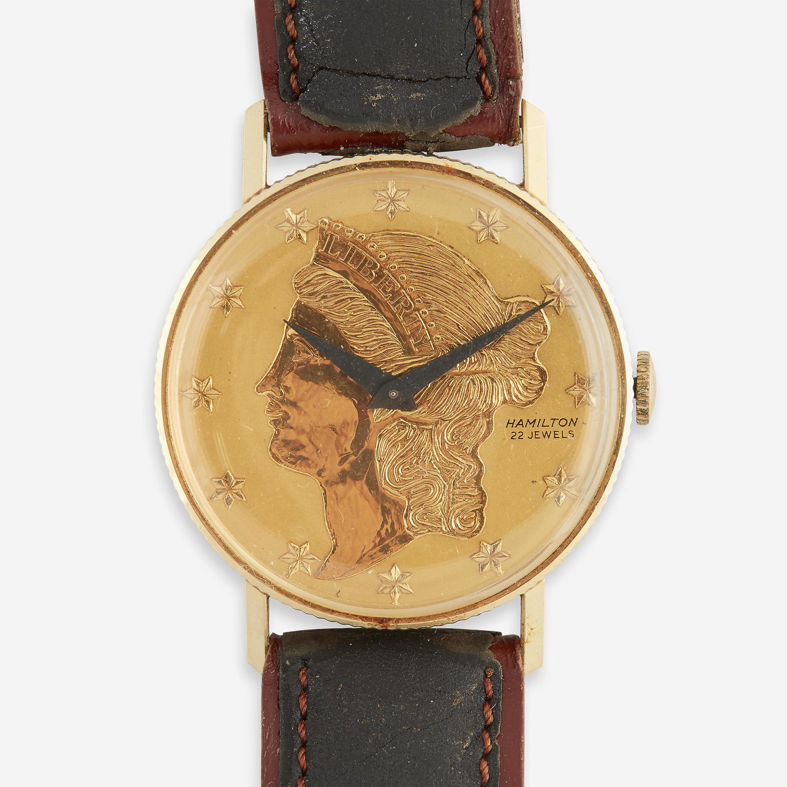 A fourteen karat gold watch, Hamilton,: A fourteen karat gold watch, Hamilton designed as a "Liberty Coin" dial with star-shaped hours, twenty-two jeweled movement, on leather strap.Case diameter: 25.0 mm; Strap length: 8 in.