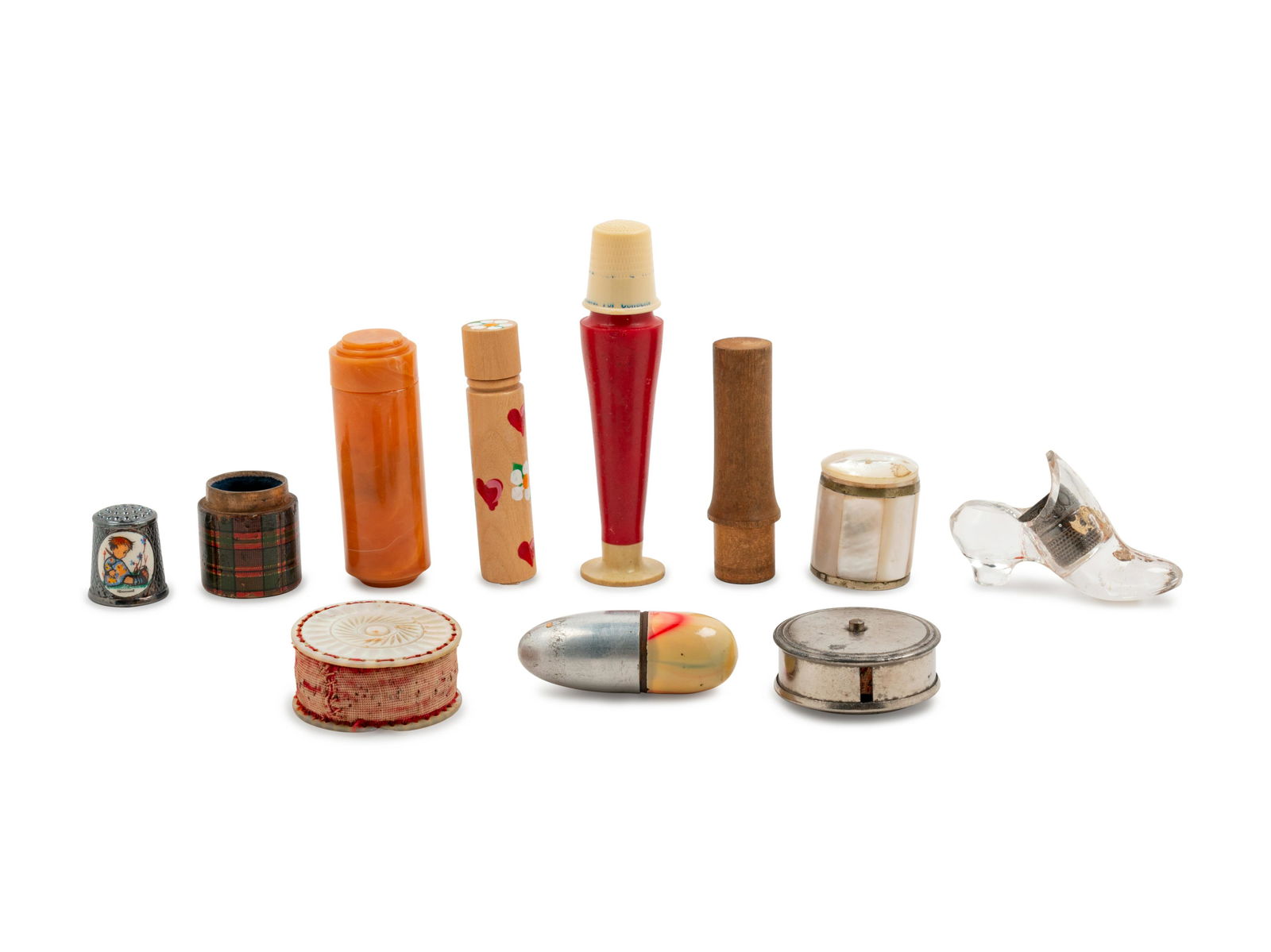 Eleven Needlework Tools: Eleven Needlework Tools comprising a Bakelite spool case, a tartanware case lacking lid, tape measures, needle cases and others. Height of tallest case 3 3/4 inches.