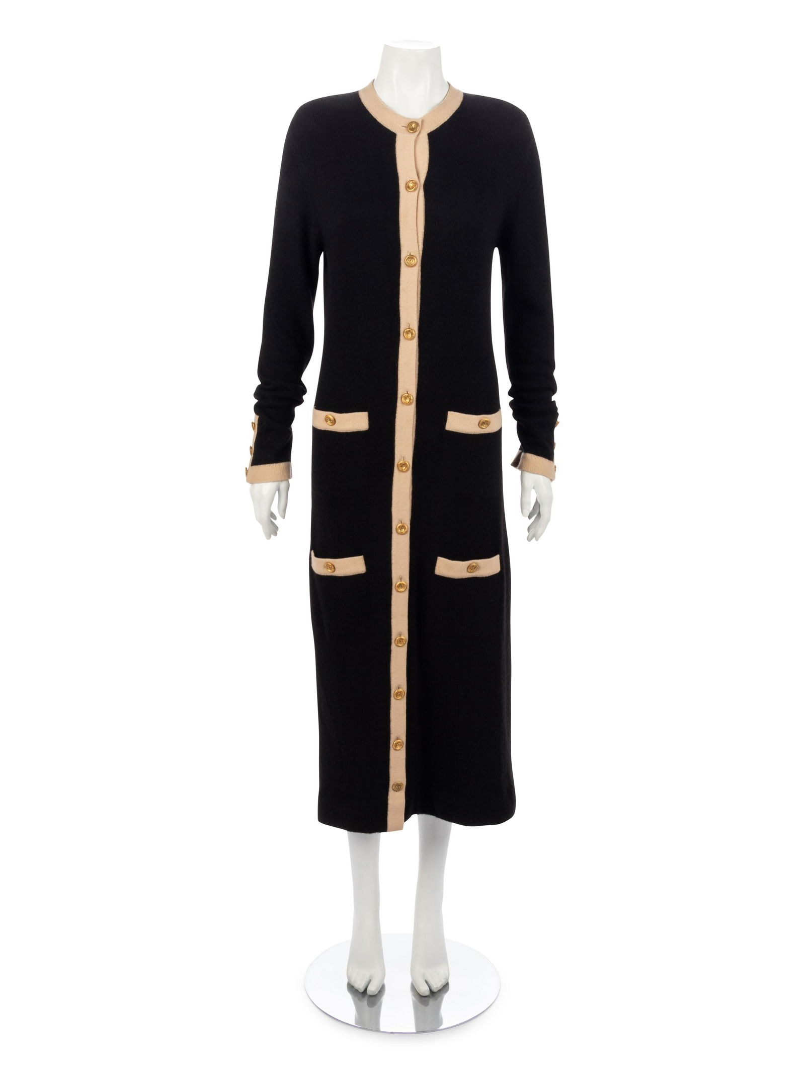 Chanel Cashmere Dress, 1993: Chanel Cashmere Dress, 1993 Black cashmere long sleeve button up dress trimmed in tan ribbed knit, four welted front pockets, and circular gold-tone CC logo buttons.† Label: Chanel† Size L
