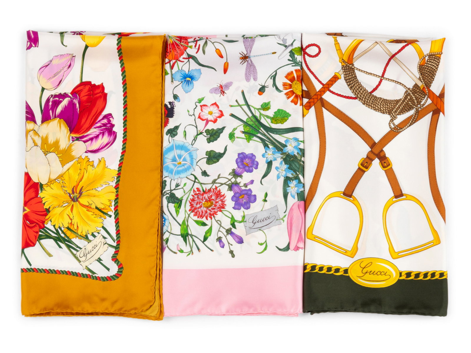 Three Gucci Scarves, 1980-2000s: Three Gucci Scarves, 1980-2000s This lot includes three scarves. THE FIRST Pink and white silk Flora pattern scarf.† Label (within the print): Gucci Approximate Measurements: Length: 35" Width: 