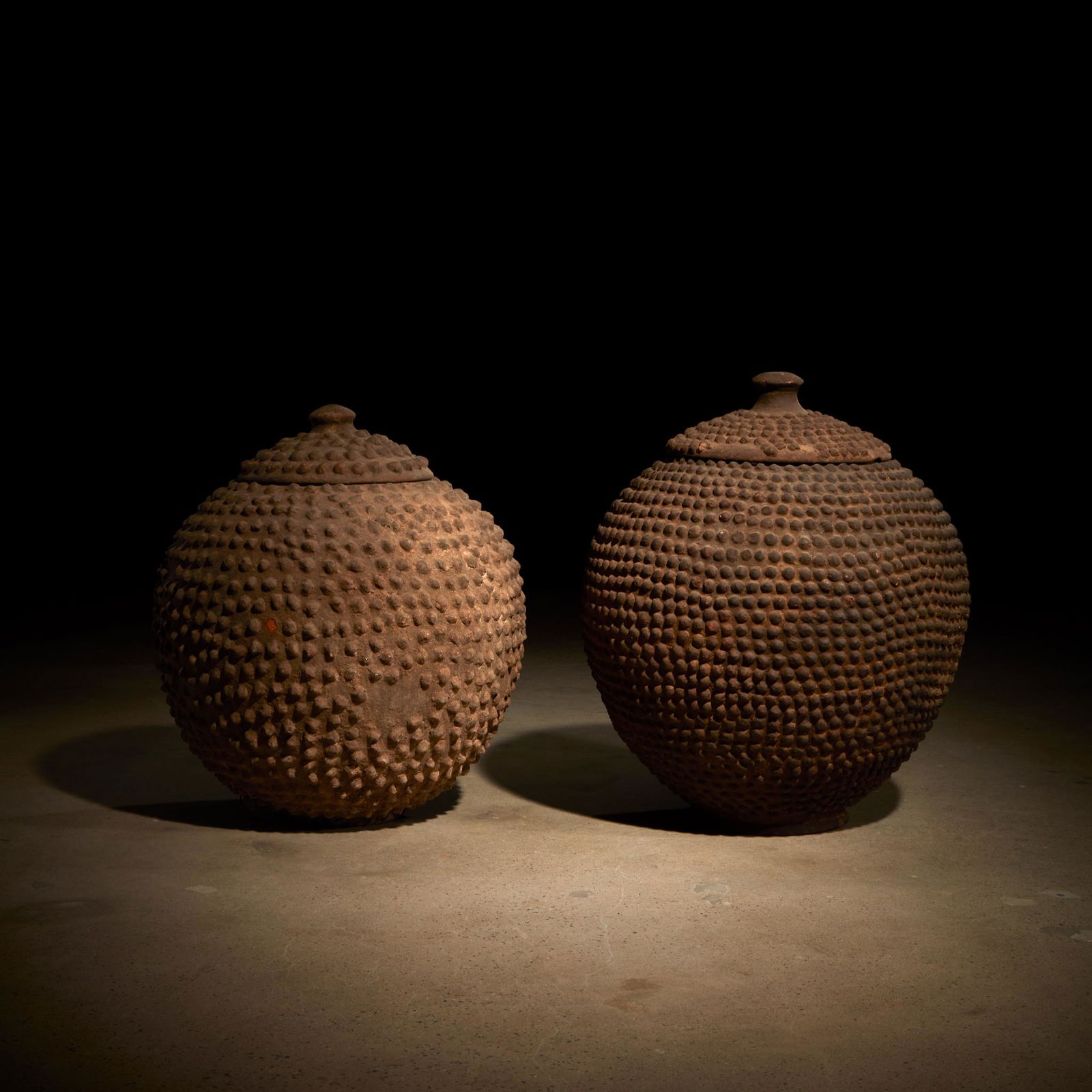 A pair of Lobi water containers, Burkina Faso: A pair of Lobi water containers Burkina FasoTerracotta, piriform shape with numerous rounded nubbins adorning the body and lid. (2).H: 22 in. (approx.)PROVENANCE:The Estate of Thomas McNemar, Lexingto